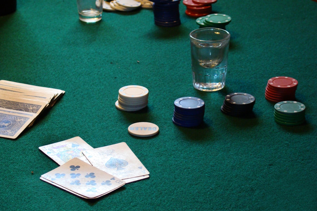 Meja poker hijau dengan susunan chip dan kartu remi