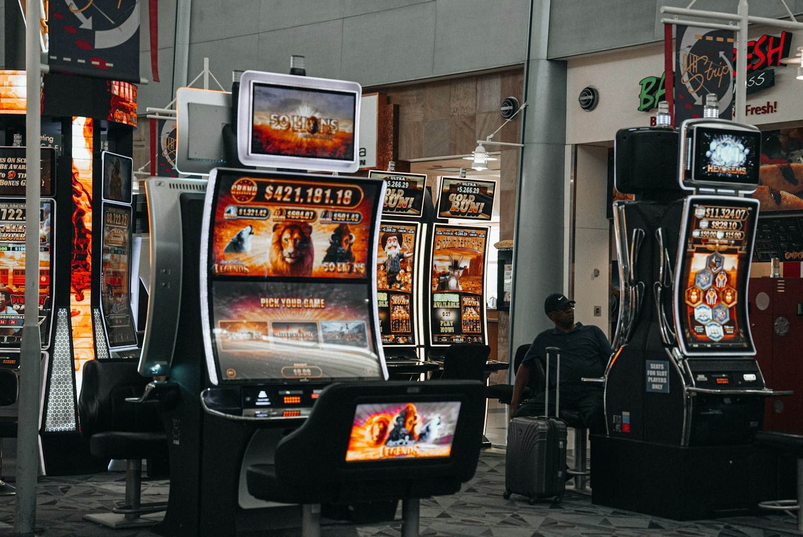 Suasana lantai permainan dengan deretan mesin slot yang menyala